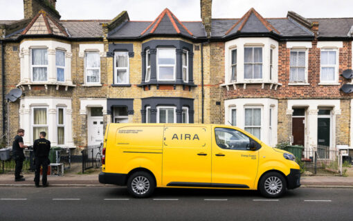 a yellow Aira van in front of a row of homes